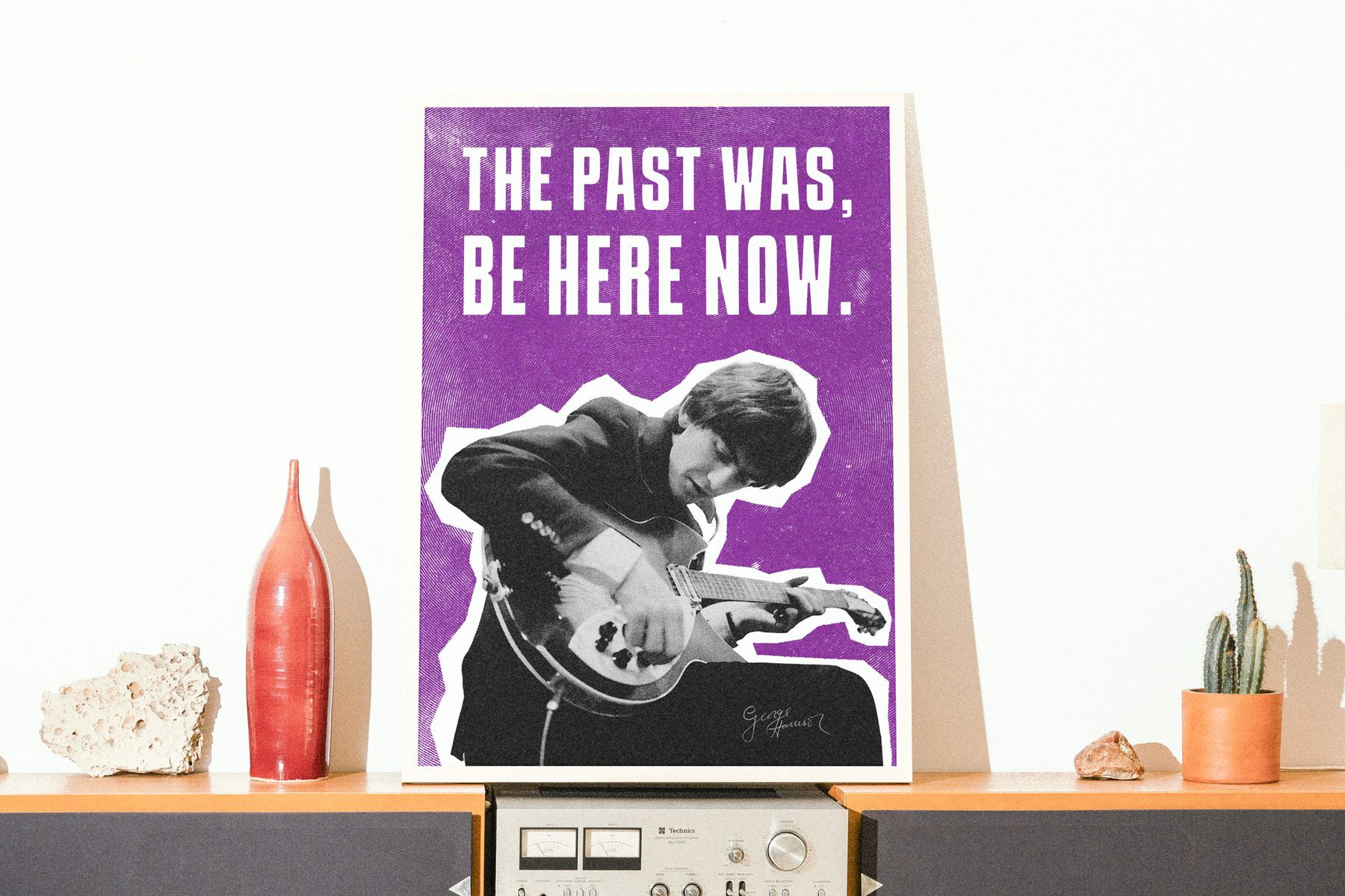 Beatles poster of George Harrison playing guitar on a purple background, framed on a shelf above a hi-fi amplifier